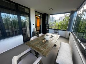 a room with a wooden table and chairs and windows at MarinaBlueGarden34 in Karaburun
