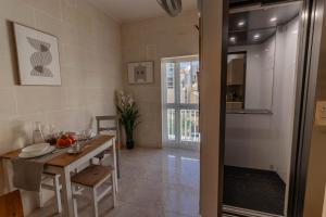 a dining room with a table and a glass door at Sea Steps 3 Marsalforn in Marsalforn