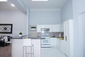 a kitchen with white cabinets and a counter with stools at New York view 39 in West New York +12 photos
