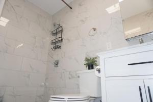 a white bathroom with a toilet and marble walls at New York view 39 in West New York