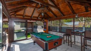 a screened in porch with a pool table at Villa Ivandvor in Split by Villas Guide in Radošić