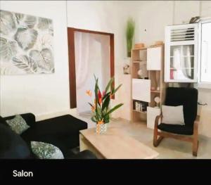 a living room with a couch and a table at Villa Ti Gîte - Piscine privée in Le Marin