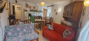 ein Wohnzimmer mit einem roten Sofa und ein Esszimmer in der Unterkunft Locanda Rum e Pera in Acquapendente