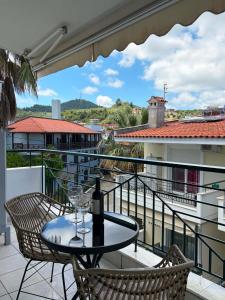 a table with a wine bottle and two glasses on a balcony at Armonia Maisonette in Pefkochori