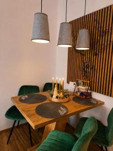a dining room table with candles and green chairs at Forest Apartment Gosau in Gosau