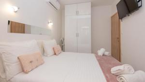 a white bedroom with a large white bed with white pillows at Villa Ivandvor in Split by Villas Guide in Radošić +32 photos
