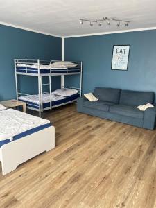 a room with two bunk beds and a couch at Jugendgästehaus Lichterfelde JuLi in Berlin