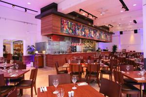 a restaurant with wooden tables and chairs and a bar at Best Seaview in Larnaca - 2 BDR Apt - 2 Min Walk to Beach in Larnaca