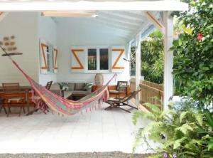 a hammock on the porch of a house at Villa Ti Gîte - Piscine privée in Le Marin