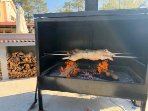 a pig is cooking in a grill with flames at Hotel Finida in Obrov
