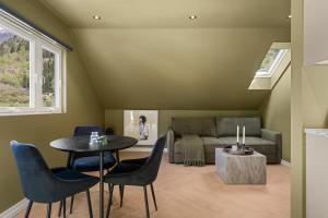 a living room with a table and chairs and a couch at Trolltunga Stay - Mountain & Waterfall View in Odda