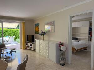 a living room with a bedroom and a bed and a television at Residenza delle Fonti by HolAp SA in Minusio