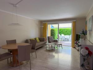 a living room with a couch and a table and chairs at Residenza delle Fonti by HolAp SA in Minusio