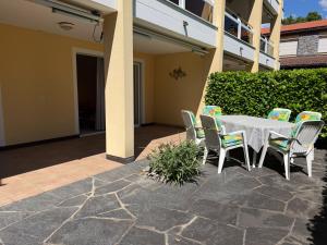 a white table and chairs on a patio at Residenza delle Fonti by HolAp SA in Minusio