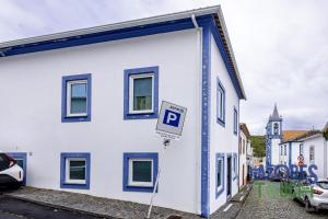 a white building with a parking sign in front of it at Casa da Misericordia in Praia da Vitória