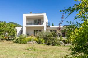 a white house with a yard in front of it at Villa Santa Mara Poggio in Santa-Maria-Poggio