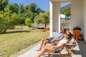 a man and woman sitting in rocking chairs on a porch at Villa Santa Mara Poggio in Santa-Maria-Poggio