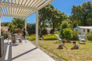 two children playing in the grass under a pergola at Villa Santa Mara Poggio in Santa-Maria-Poggio