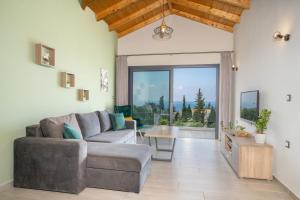 a living room with a couch and a large window at Vista Blu Villas in Vlachata
