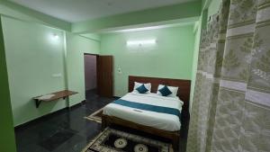 a bedroom with a bed in a room with a wall at Tree Top Residency in Mysore