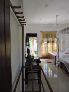 a living room with a staircase and a bedroom at Seadina Coral Home in Matara