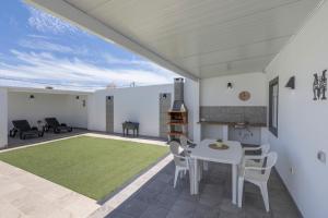 a patio with a table and chairs and a green rug at Casa Muley in El Matorral