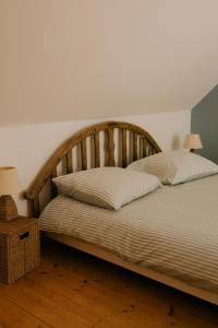 a bed with a wooden headboard and two pillows at Le Refuge Bourguignon in Nuits-Saint-Georges +9 photos