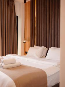 two beds in a hotel room with white pillows at Foga Aus in Ksamil +16 photos
