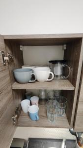 a shelf with bowls and other kitchen utensils at Apartmán pro 4 osoby, Most M1 in Most
