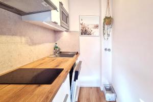 a kitchen with a sink and a wooden counter top at Strandliebe in Scharbeutz, 150m zum Strand! Sonnenbalkon, ruhig gelegen, kostenfreier Parkplatz, Fahrstuhl in Scharbeutz