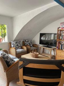 a living room with couches and a flat screen tv at Moya, relax en la Calderona in Gilet