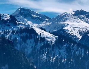 a mountain range with snow covered mountains at Negi Wooden House in Manāli +3 photos