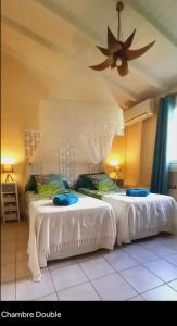 two white beds in a room with a ceiling at Villa Ti Gîte - Piscine privée in Le Marin