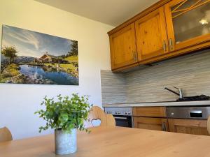 a kitchen with a wooden table with a vase on it at Der Waidachhof Zillertal in Hainzenberg +111 photos