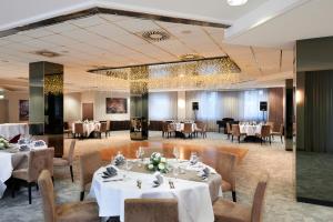 a dining room with white tables and chairs at NOVINA HOTEL Südwestpark in Nuremberg