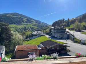 a view of a village with a green hill at Der Waidachhof Zillertal in Hainzenberg