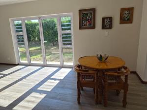 a dining room with a wooden table and chairs at Crocus Corner - Kyalami in Kyalami