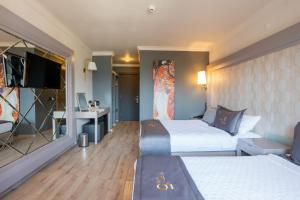 a hotel room with two beds and a flat screen tv at FIFTY5 Suite Hotel in Marmaris