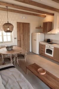 a kitchen with a table and a white refrigerator at Elion Private Pool Villas in Kos
