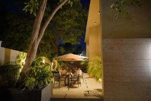 two people sitting at a table in a garden at night at Central Residence by Paramount Hospitality in Karachi