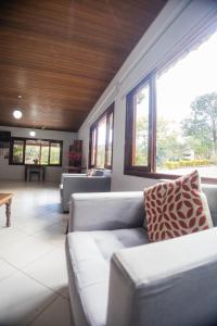 a living room with a couch and windows at Chalés Casa Rosa in Alto Paraíso de Goiás +148 photos