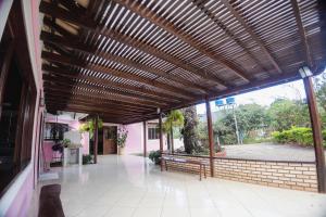a building with a wooden pergola with a patio at Chalés Casa Rosa in Alto Paraíso de Goiás