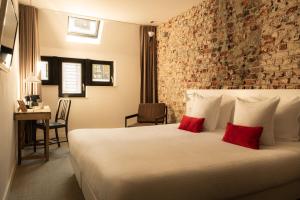 a hotel room with a large bed with red pillows at 9Hotel Central in Brussels