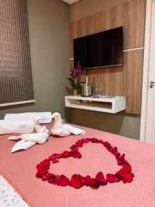 a pink bed with a heart made out of roses at Apartamento Exec Premium Queen Bed Centro-Taubate in Taubaté