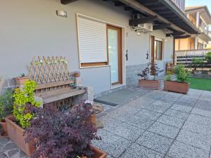 a house with potted plants and a wooden bench at Adriroomsrho in Rho