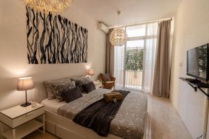 a bedroom with a bed and a large window at Sea Steps Marsalforn in Marsalforn