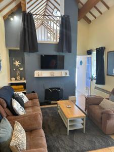 a living room with a couch and a table at Boatman's Cottage in Rhoscolyn