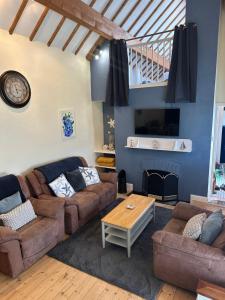 a living room with two couches and a fireplace at Boatman's Cottage in Rhoscolyn