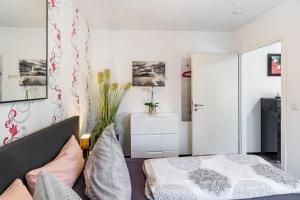 a bedroom with a bed and a white wall at Ferienwohnung Koje 1 in Wangerland