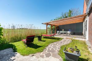 a patio with chairs and a table in a yard at Ferienwohnung Koje 1 in Wangerland